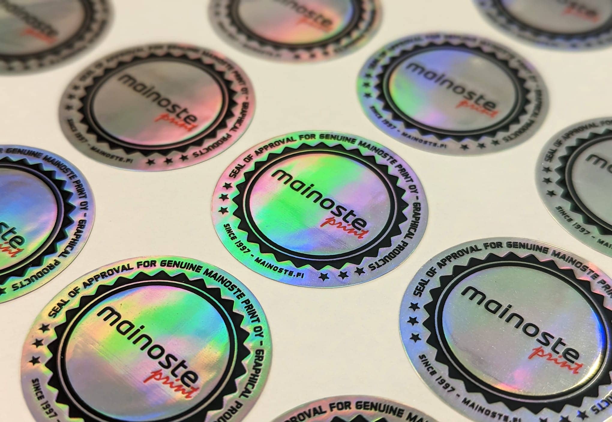 Mainoste Printin pyöreitä hologrammilogotarroja arkilla