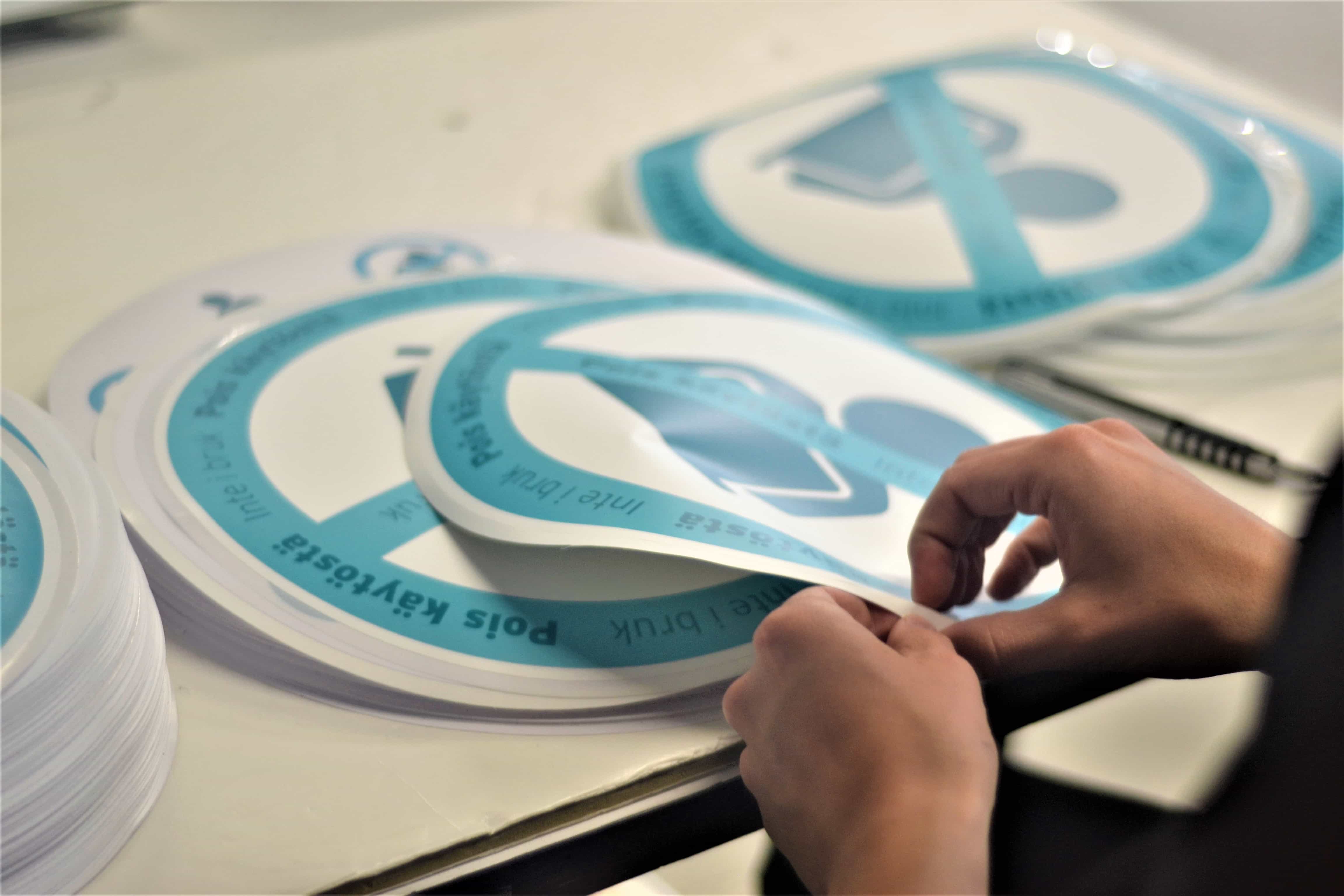 Tuotannon työntekijä perkaa tarroja